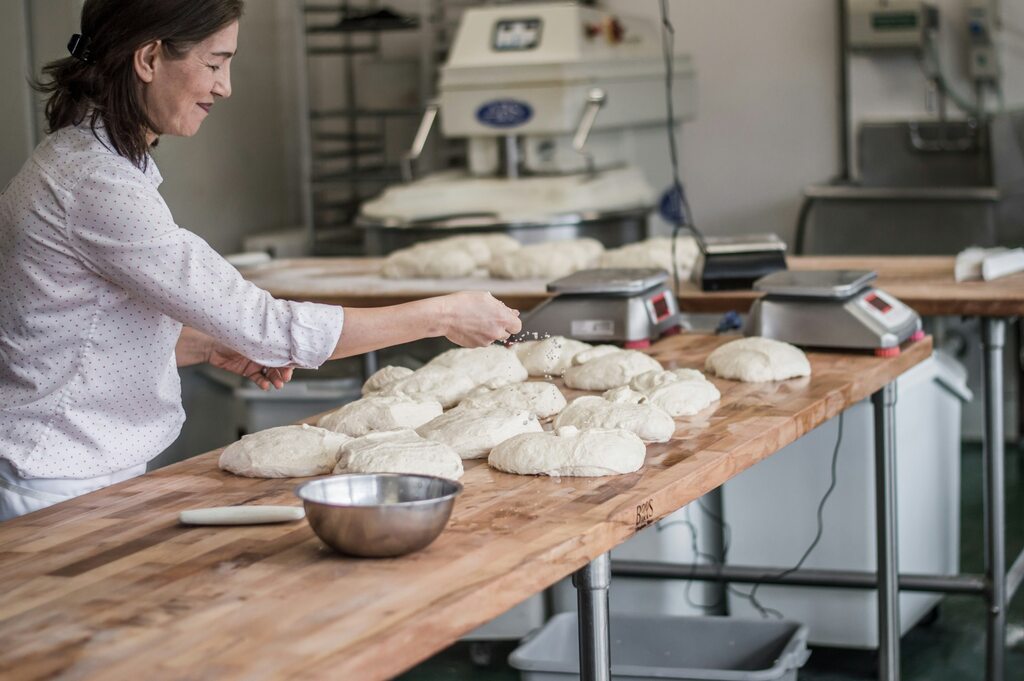Cozinheira sorridente com os resultados do uso da melhor margarina em seus produtos