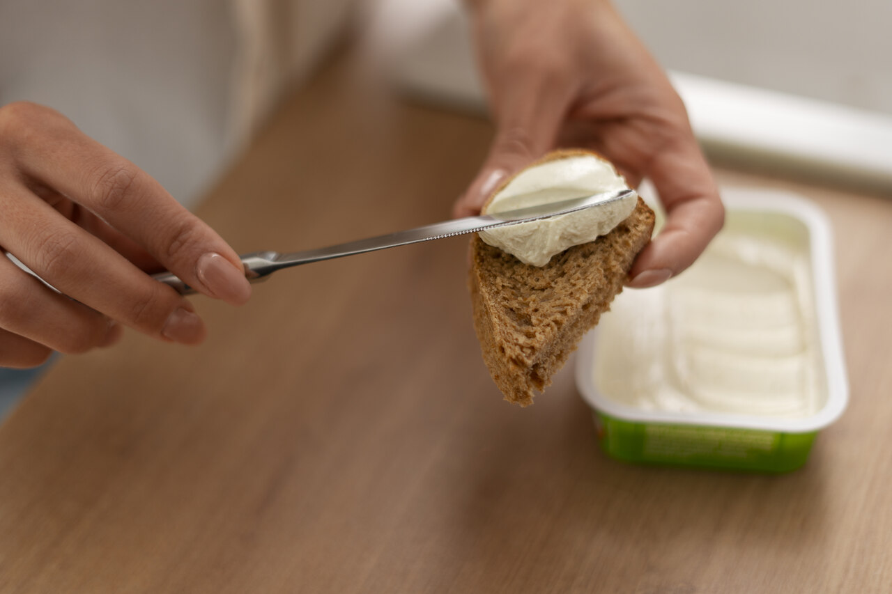 margarina sendo aplicada em pão integral para consumo no dia a dia