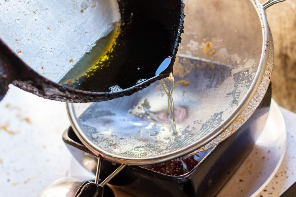 óleo de cozinha velho sendo coado após uso excessivo indicando processo de rancificação da gordura