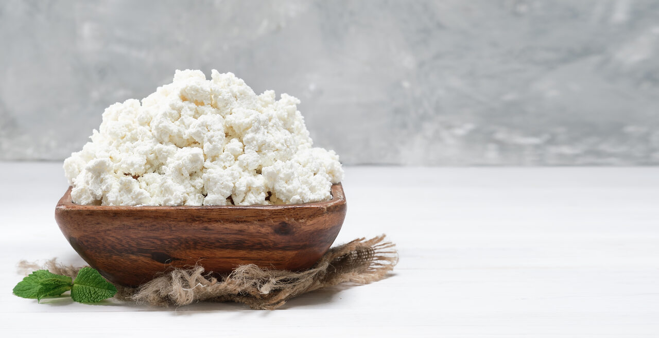 Margarina em textura granulada em tigela de madeira com fundo claro